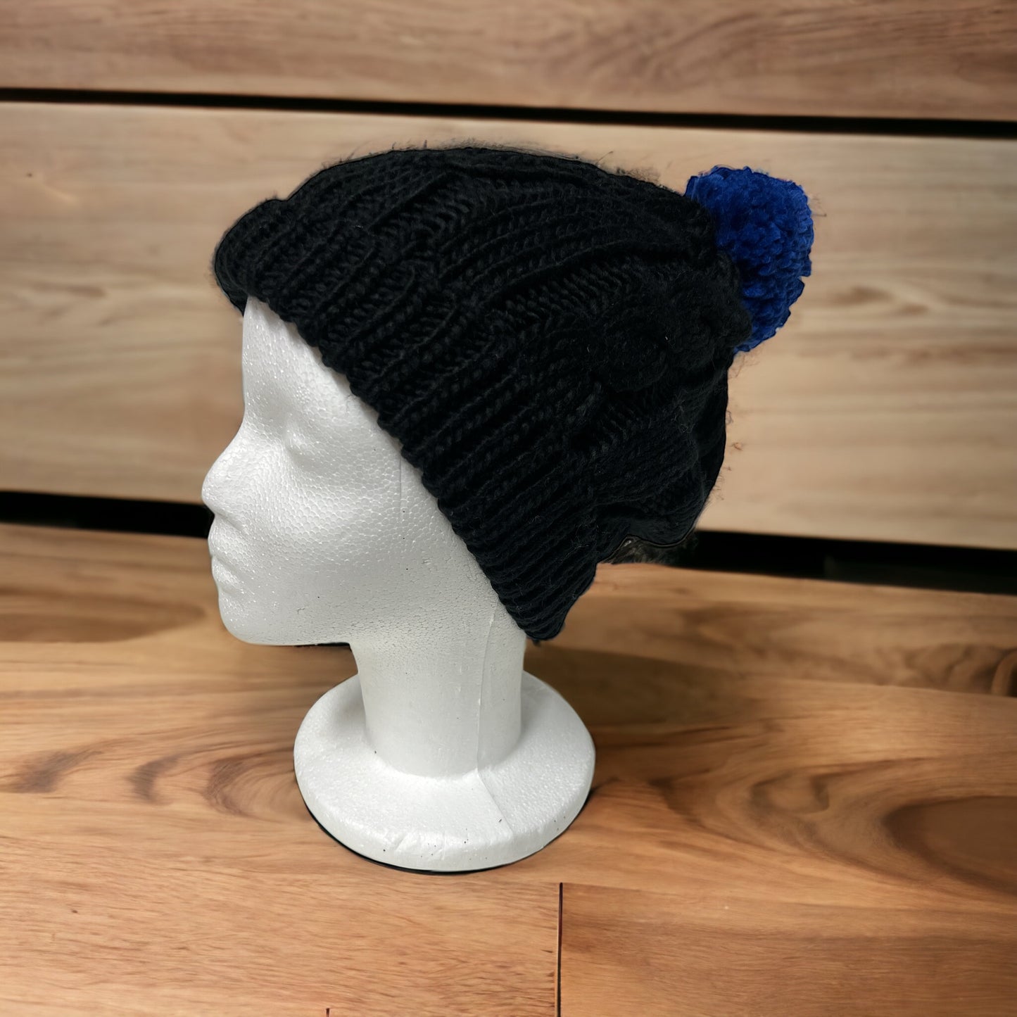 Warme und bequeme Strickmütze in Schwarz mit blauem Bommel